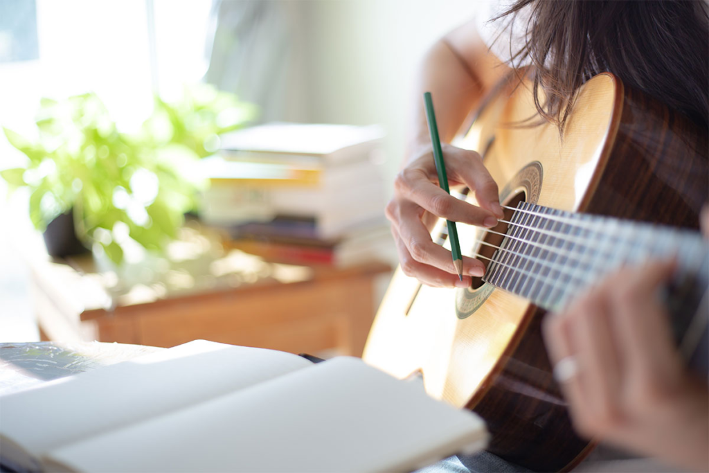 music-therapy-someone-playing-guitar-with notebook