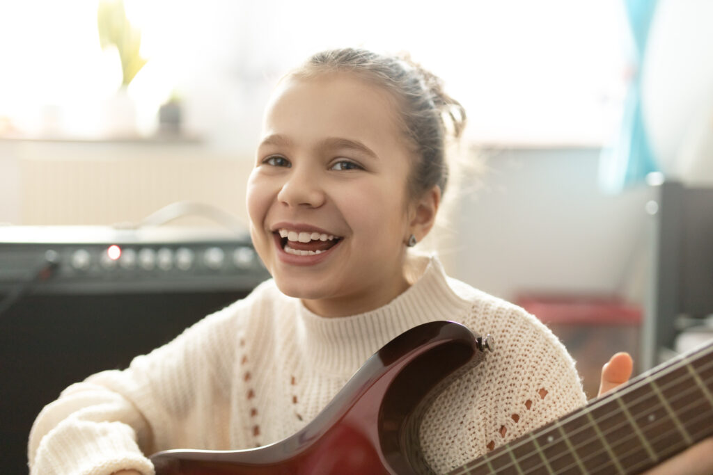 music-therapy-girl-laughs-with-guitar